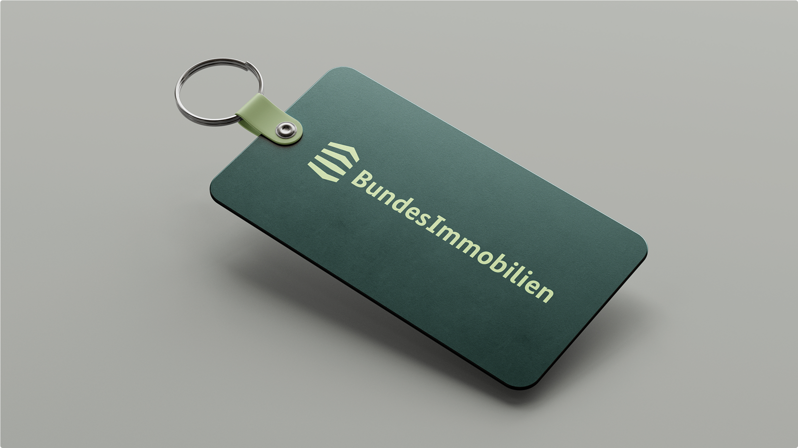 Ein dunkelgrüner Schlüsselanhänger mit dem Logo von Bundesimmobilien.