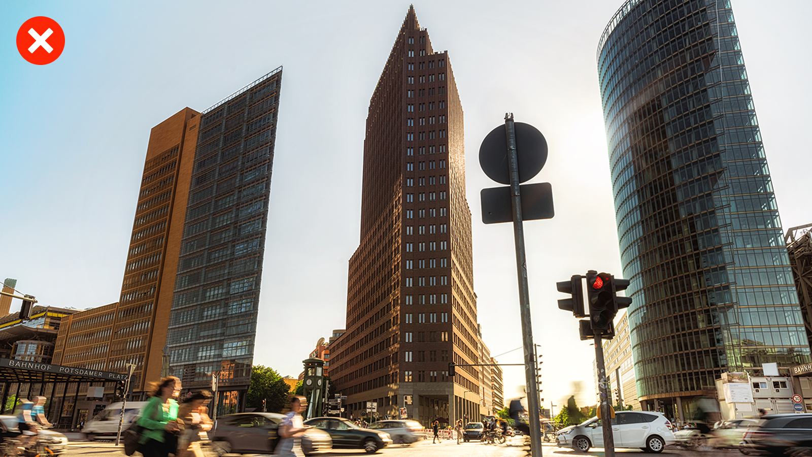 Hohe moderne Gebäude an einer belebten Kreuzung, bei sonnigem Wetter. die Gebäude wirken verzerrt.
