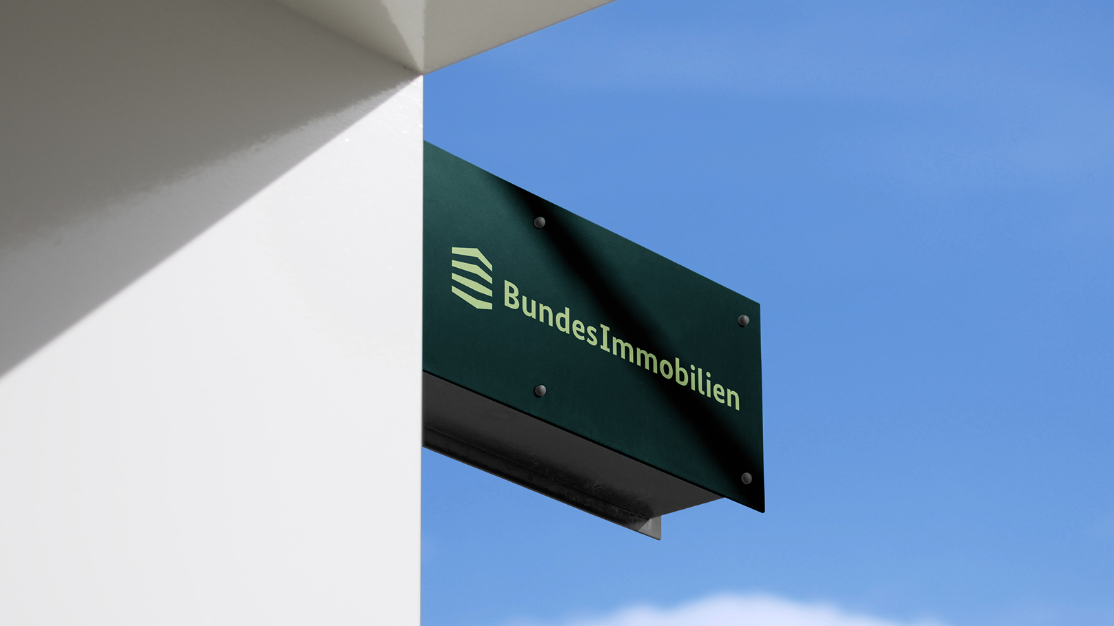 Dunkelgrünes Schild mit hellgrünem BundesImmobilien-Logo.