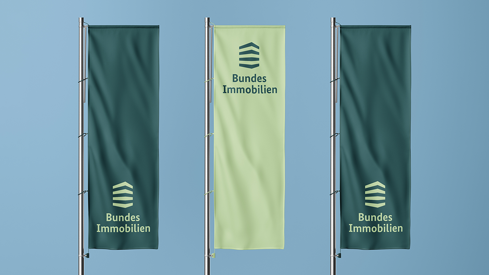 Drei Fahnen mit dem Logo von Bundesimmobilien, zwei dunkelgrün und eine hellgrün.