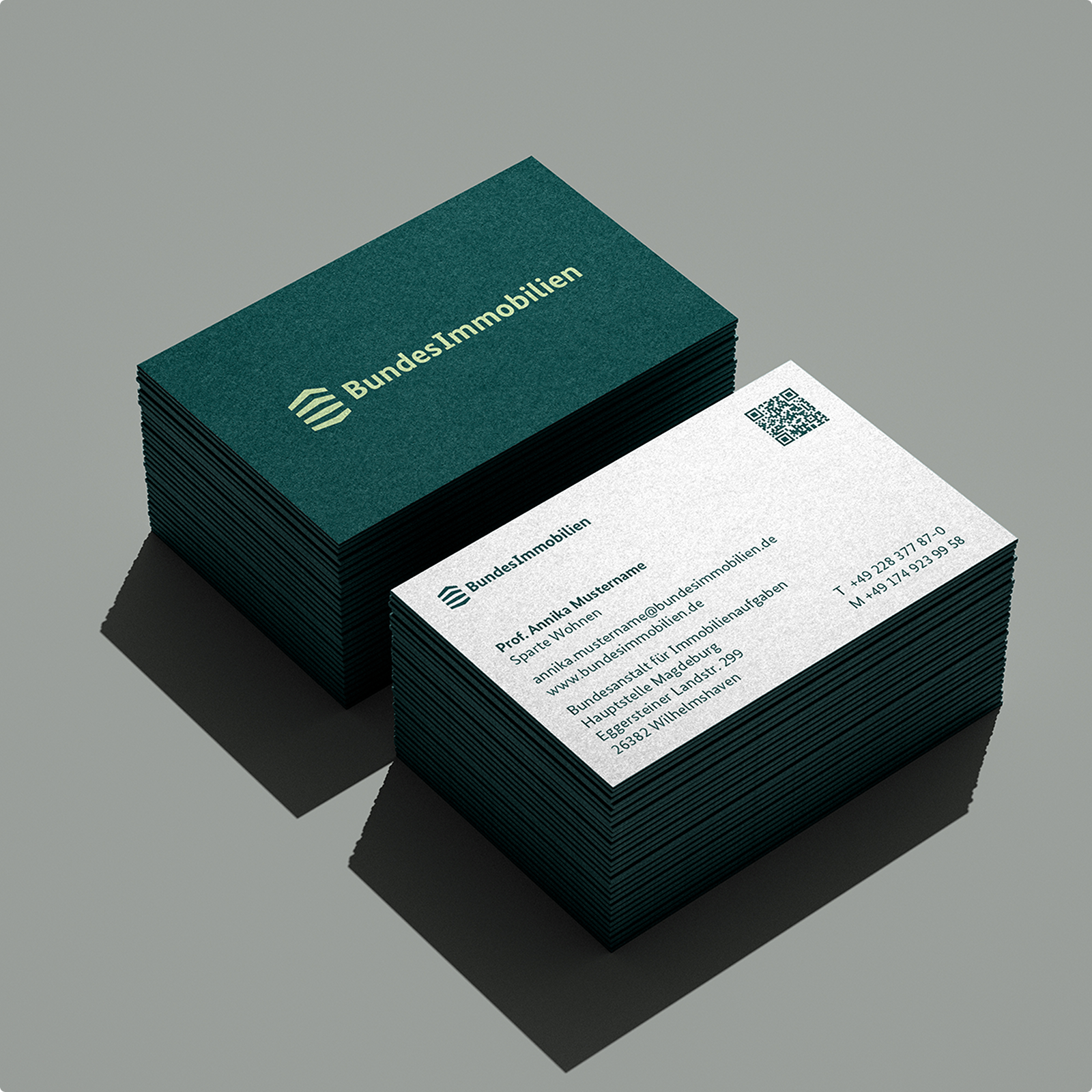 Zwei Stapel von Visitenkarten der Bundesimmobilien. Eine Karte zeigt das Logo und Kontaktdaten, die andere die Rückseite mit dem Logo.